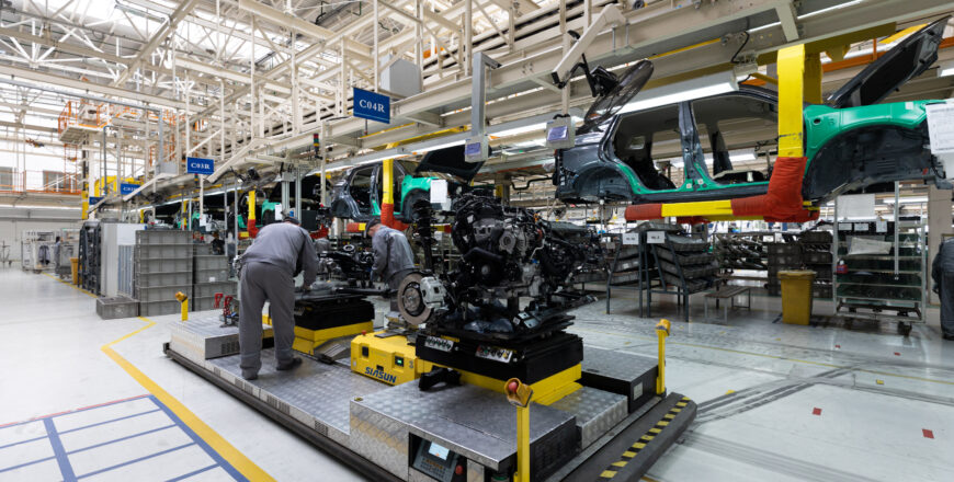 Photo of car bodies are on assembly line. Factory for production of cars. Modern automotive industry