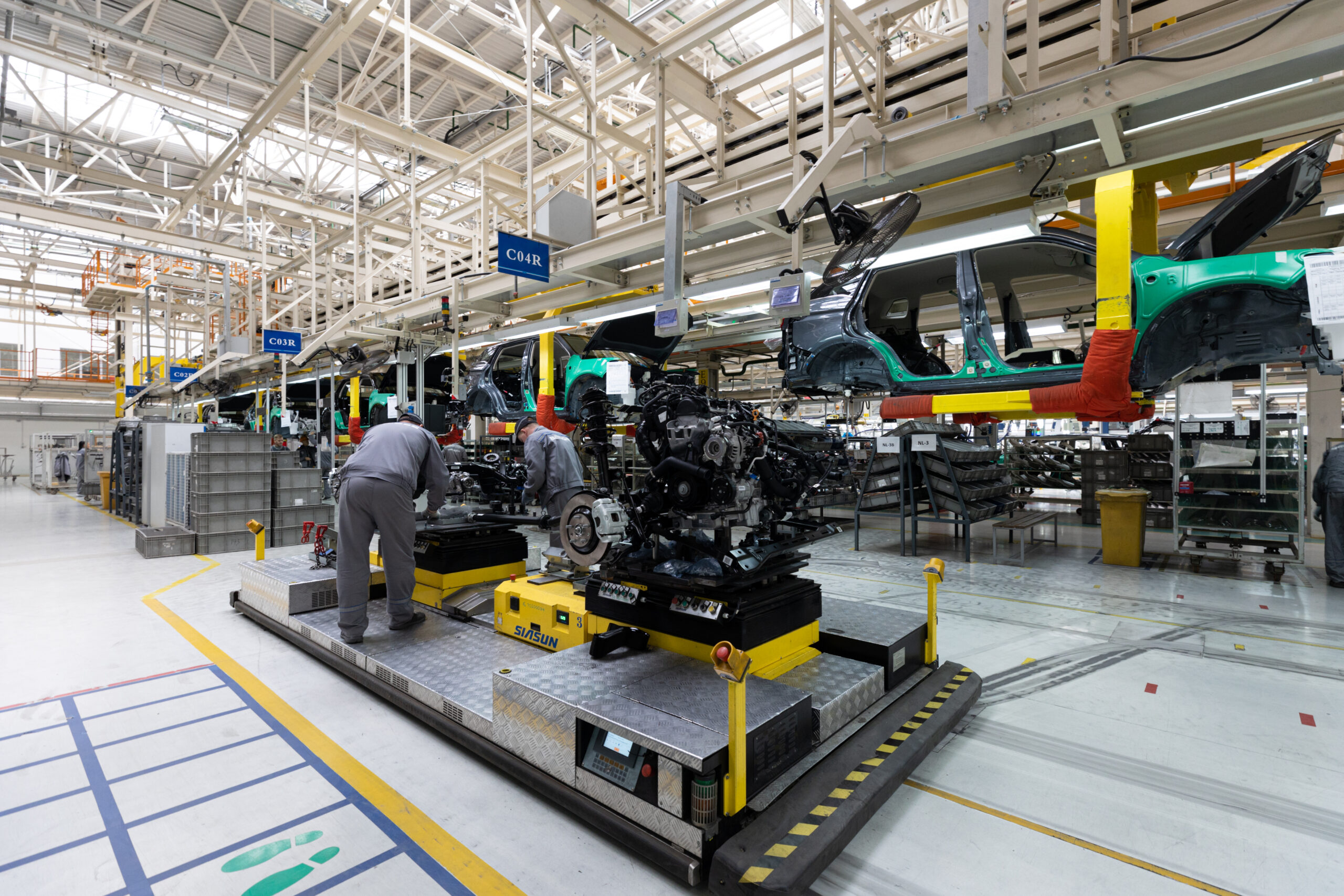 Photo of car bodies are on assembly line. Factory for production of cars. Modern automotive industry